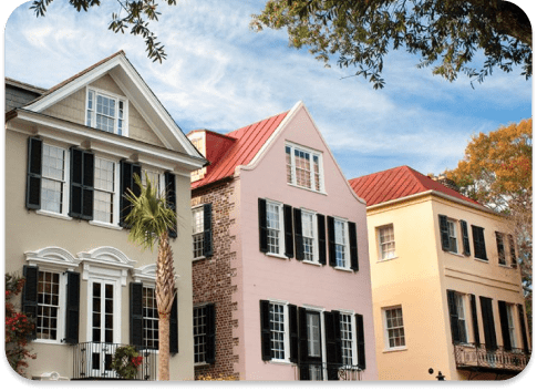 A row of historic homes with freshly painted siding and black shutters