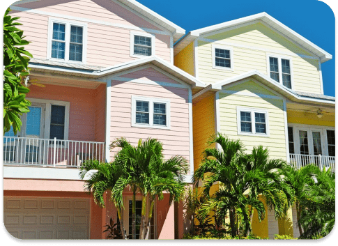 Pastel-painted coastal townhouses with palm trees in the foreground