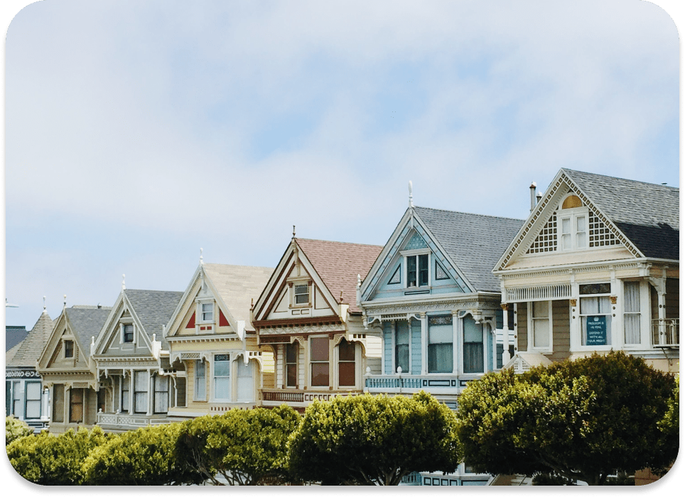 A row of painted Victorian houses with detailed trim work